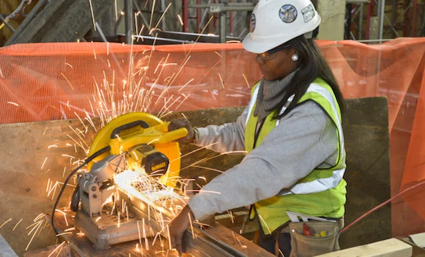 African-American woman operating construction equipment